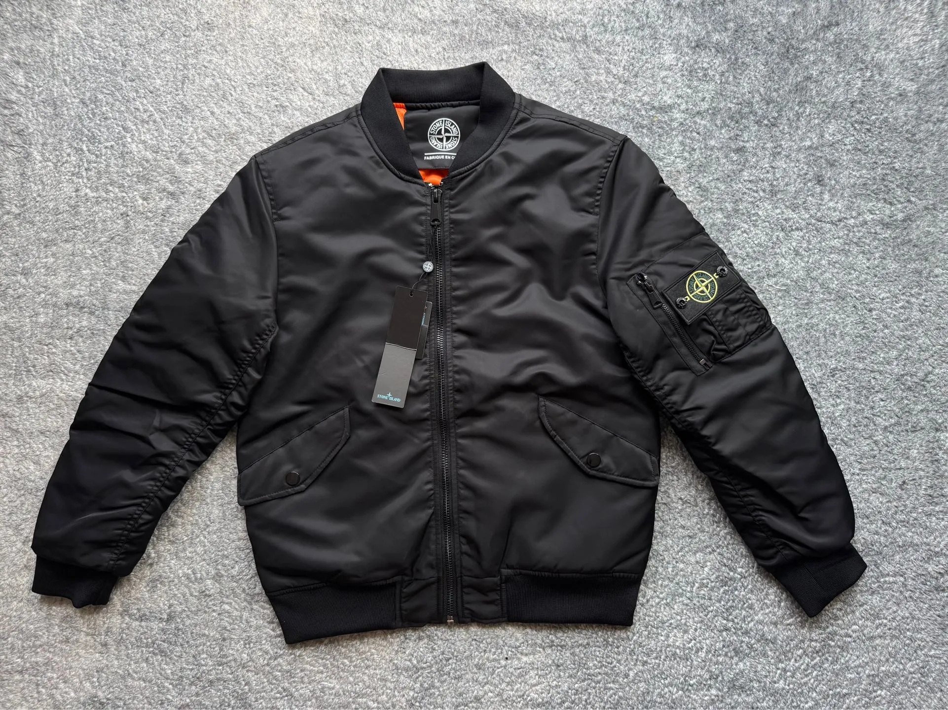 P360 Stone lsland Stone Island Medal Aviator Cotton Jacket The outer fabric is made of MA-1 flight nylon, which is a material specially used in flight and aviation. Flying nylon is a fabric specially used in flight and aviation. It is rarely used in ordinary clothing. The density of flying nylon is very high, so it is windproof and waterproof. When rain falls on the surface of the clothes, it will not penetrate immediately, but will form a small water droplet and slide off. This performance is a requirement for the development of modern jet technology. Because it is assumed that the pilot got caught in the rain before getting on the plane, he entered the cabin covered in rainwater. When flying at high altitude and at high speed, in a cabin without an environmental control system, water droplets will freeze on the pilot's body 2. Knitted baseball collar MA-1 uses a knitted collar. The collar is made of wool and can be snug around the neck and very warm. 3. Metal zippers We have very strict requirements on zippers, including smoothness and size. There was no zipper on the market that met the requirements, so we asked a zipper factory to customize a strong and durable metal zipper.  4. Double-threaded knitted cuffs The cuffs are made of double-threaded knitted fabric, narrow at the front and wide at the back. The narrow part can be tightened around the wrist to prevent wind from entering. The wide part has enough space when wearing multiple pieces under winter Color: Black Dark Army Green Size: M L.